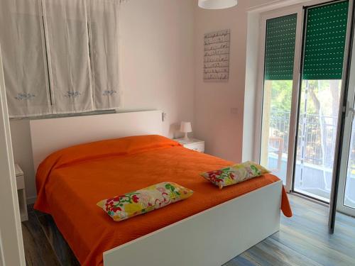 una camera da letto con un letto arancione con due cuscini sopra di AGUA VISTA APARTMENT ad Agropoli