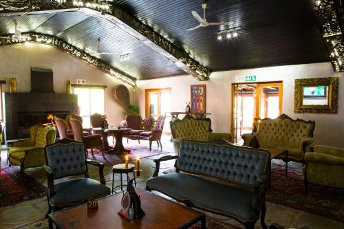 a room with chairs and tables and a fireplace at Misty Hills Country Hotel, Conference Centre & Spa in Muldersdrift