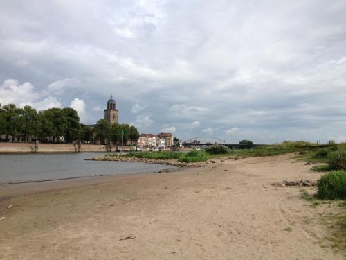 a beach with a clock tower in the distance at Hanzestadslogement "De Leeuw", logies in het centrum van Deventer in Deventer