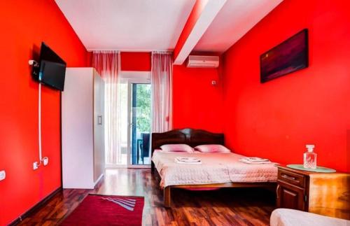 a bedroom with red walls and a bed with pink pillows at 500 Meters from Grate Beach, App 1 in Ulcinj