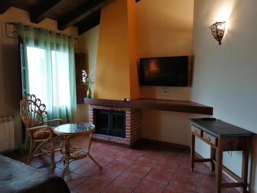 a living room with a tv and a fireplace at La Posada de Horcajuelo in Horcajuelo de la Sierra