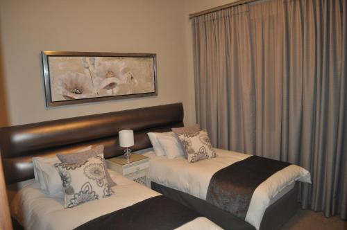 Habitación de hotel con 2 camas y ventana en A Perfect Self Catering, en Wellington