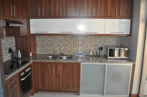 a kitchen with wooden cabinets and a sink and a microwave at A Perfect Self Catering in Wellington