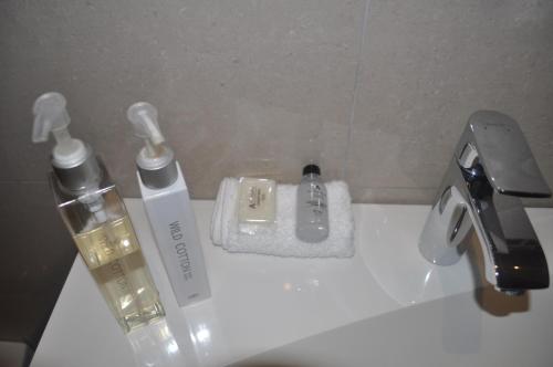 un baño con 2 botellas de odorizantes en un lavabo en A Perfect Self Catering, en Wellington