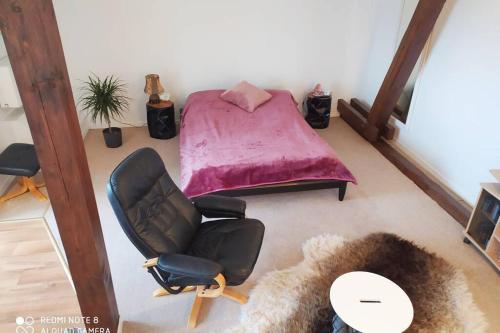 a bedroom with a bed and a chair and a table at Studiowohnung in Bergen/Bleckmar in Bergen