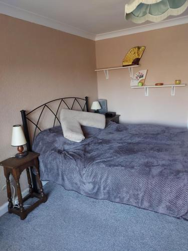 ein Schlafzimmer mit einem Bett und einem Tisch mit Lampen in der Unterkunft JOE'S PLACE in Retford