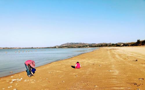 a man and a child playing on the beach at 金門后倉七號新古厝民宿 in Jinning