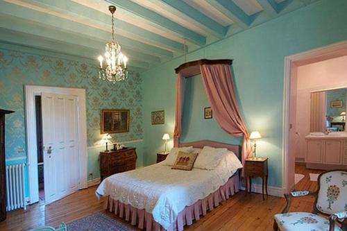 une chambre avec un lit et un lustre dans l'établissement Château de Nazé Vivy-Saumur, à Vivy