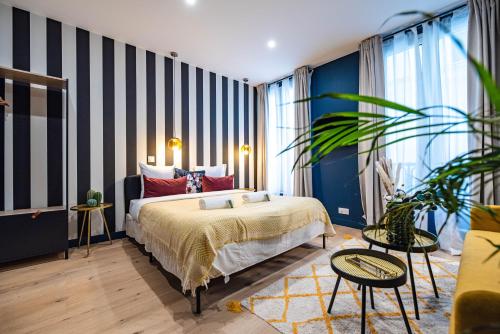 - une chambre avec un lit et un mur rayé dans l'établissement Monsieur Pigalle, à Paris