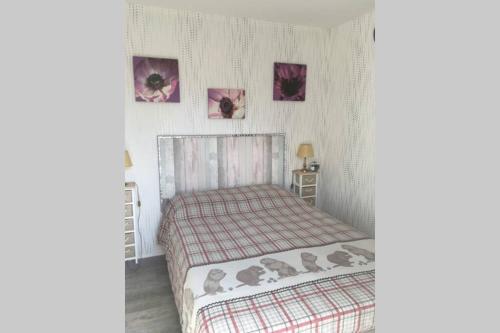 1 dormitorio con 1 cama y 2 cuadros en la pared en appartement au Hameau du parc des thermes, en Bagnoles de l'Orne