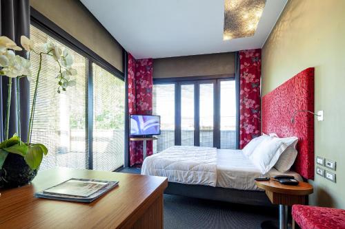 a bedroom with a bed and a desk and a tv at Là Di Moret in Udine