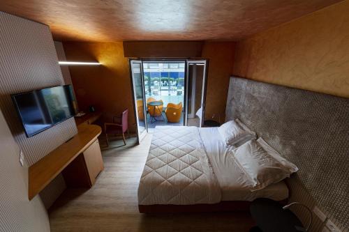 a bedroom with a bed and a tv and a balcony at Là Di Moret in Udine
