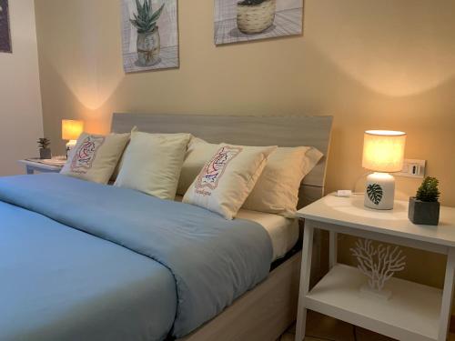 a bed with a blue comforter and pillows in a bedroom at La Marina Apartment with Pool in Olbia