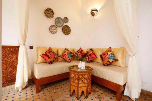 a living room with a couch and clocks on the wall at Afla Views Imlil in Imlil