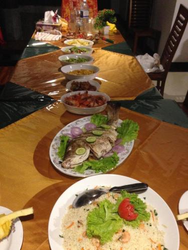 a long table with plates of food on it at Avon Villa in Hikkaduwa