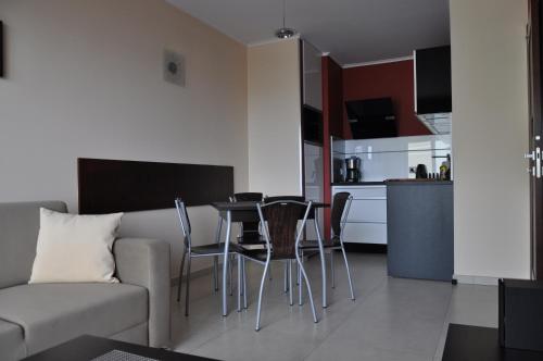 a living room with a couch and a table and chairs at Promenada28pl - Apartamenty z widokiem na morze in Międzyzdroje