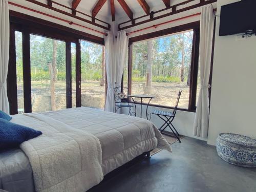 ein Schlafzimmer mit einem Bett und einem großen Fenster in der Unterkunft Casa Dino en Villa de Leyva in Villa de Leyva