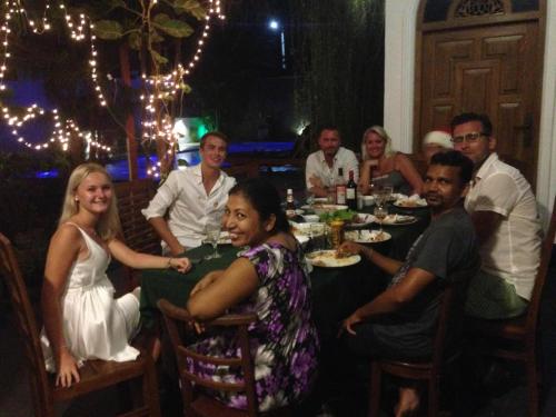a group of people sitting around a table eating at Avon Villa in Hikkaduwa