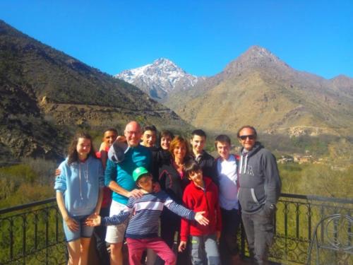 a group of people posing for a picture with mountains in the background at Afla Views Imlil in Imlil