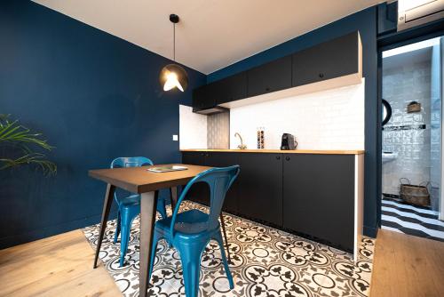 une cuisine avec une table en bois et des chaises bleues dans l'établissement Monsieur Pigalle, à Paris
