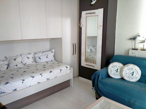 a bedroom with a bed and a blue couch at Studio Penthouse Nieuwpoort in Nieuwpoort