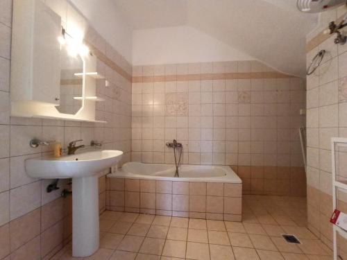 a bathroom with a sink and a bath tub at Doras House in village Άνετο Διαμέρισμα υπέροχη θέα in Pyrgadikia