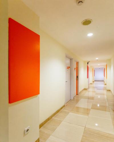 a hallway of an office building with a red painting on the wall at Front One Inn Muntilan in Muntilan