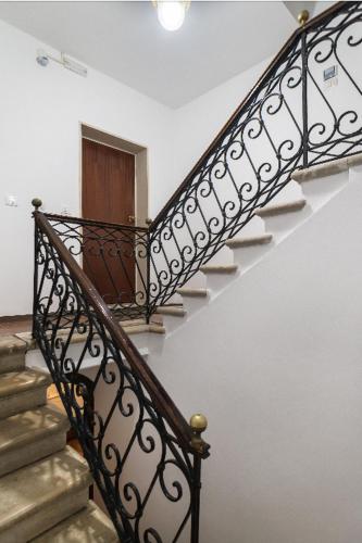 a staircase with a wrought iron railing in a house at Casa Bastianello favolosa vista sul Canale Vena in Chioggia