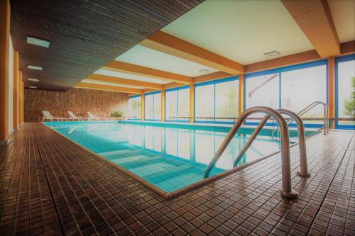 an indoor swimming pool with a pooliteratoriteratorachuythonythonythonython at LAAX Central Holiday Apartment with Pool & Sauna in Laax