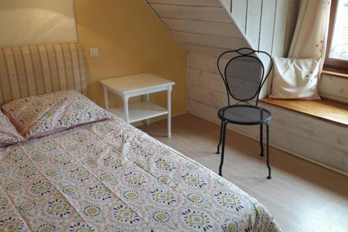 a bedroom with a bed and a chair and a window at Ti Aval - Gîte de charme à la campagne - côte de granit rose in Bégard