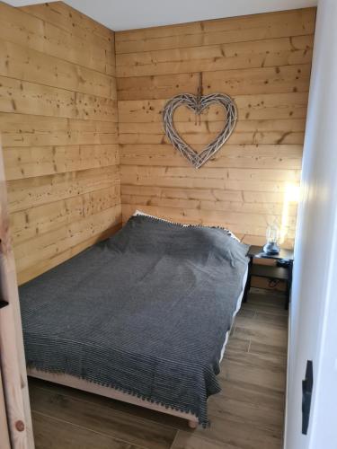 a bedroom with a bed with a heart sign on the wall at Appartement 4 pers. pied des pistes Les 2 Alpes in Les Deux Alpes