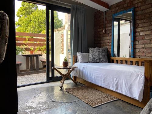 um quarto com uma cama e uma grande janela em RElaxed city living em Port Elizabeth