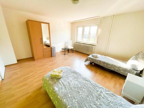 um quarto com 2 camas e piso em madeira em Preiswertes zentrales WG-Zimmer in Ravensburg em Ravensburg