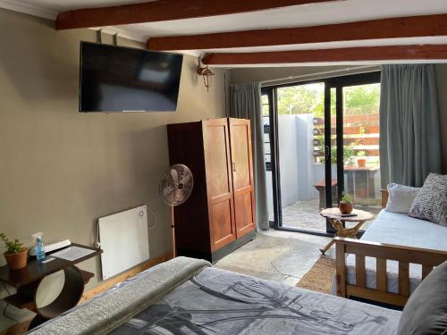 a bedroom with a bed and a flat screen tv at RElaxed city living in Port Elizabeth