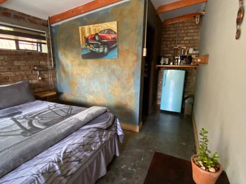 a bedroom with a bed and a painting of a car on the wall at RElaxed city living in Port Elizabeth
