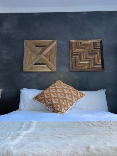a bed with two pieces of wood on the wall at RElaxed city living in Port Elizabeth