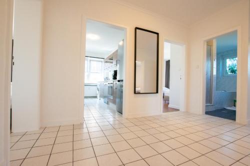 a hallway with a tile floor and a mirror at RAJ Living - 1 , 3 and 4 Room Apartments - 20 min Messe DUS & Airport DUS in Meerbusch