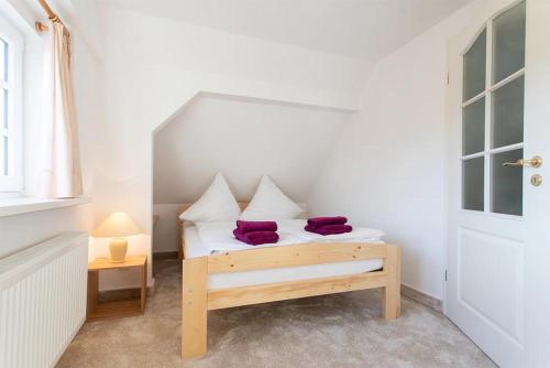 een kleine slaapkamer met een bed met paarse kussens erop bij Altes Rathaus Hahnenklee in Hahnenklee-Bockswiese