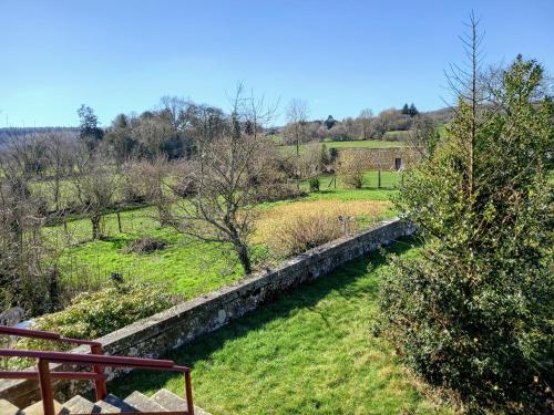 a view of a garden with a stone wall at le gite du jardinier in Saint-Martin-lʼAiguillon