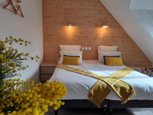 a bedroom with a bed with white sheets and yellow pillows at CHARMES EN VILLE Le Charme Authentique in Montluçon