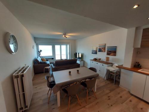 een keuken en een woonkamer met een tafel en stoelen bij zeedijk westende in Middelkerke