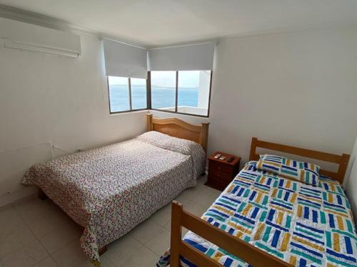 a bedroom with two beds and two windows at Apartamento Amoblado en Cartagena de Indias in Cartagena de Indias