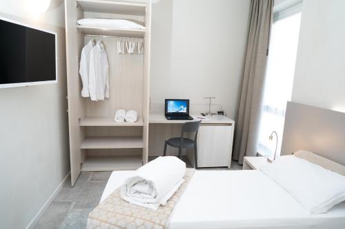 a bedroom with two beds and a desk with a computer at Hotel Europa in Dossobuono