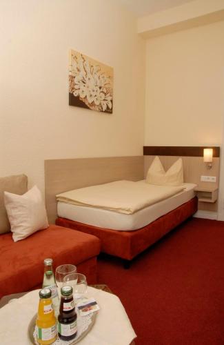 a hotel room with two beds and a table at Hotel Wuppertaler Hof in Remscheid