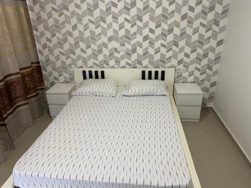 1 dormitorio con 1 cama blanca y 2 mesitas de noche en Bellamy, en Porto Novo