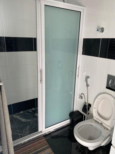 a bathroom with a shower and a toilet with a glass door at Bellamy in Porto Novo