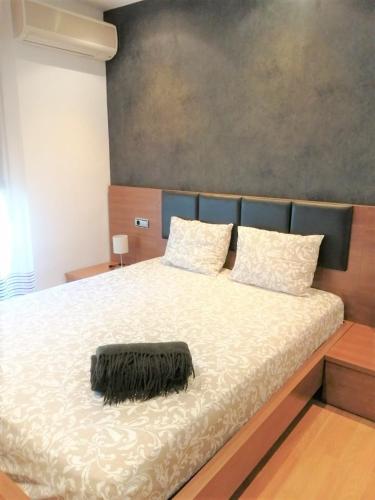 a large bed with a black blanket on it at APARTAMENTO HUESCA in Huesca