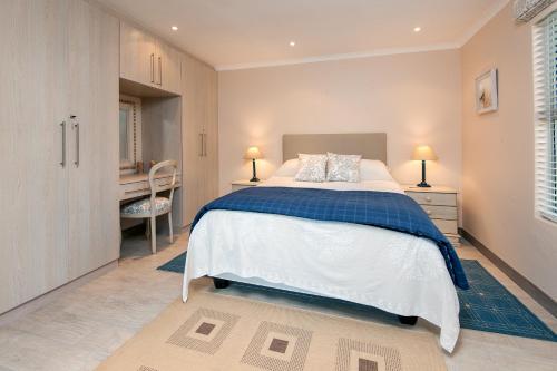 a bedroom with a large bed and a desk at Hermanus Haven, entire home, on the sea, private pool, secure in Hermanus