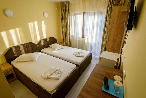a hotel room with two beds and a table at Casa Domneasca Riana in Piteşti