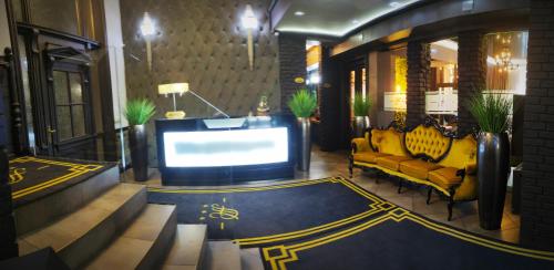 Hotel Fado في جورزو فيلكوبولسكي: غرفة معيشة مع أريكة صفراء وتلفزيون